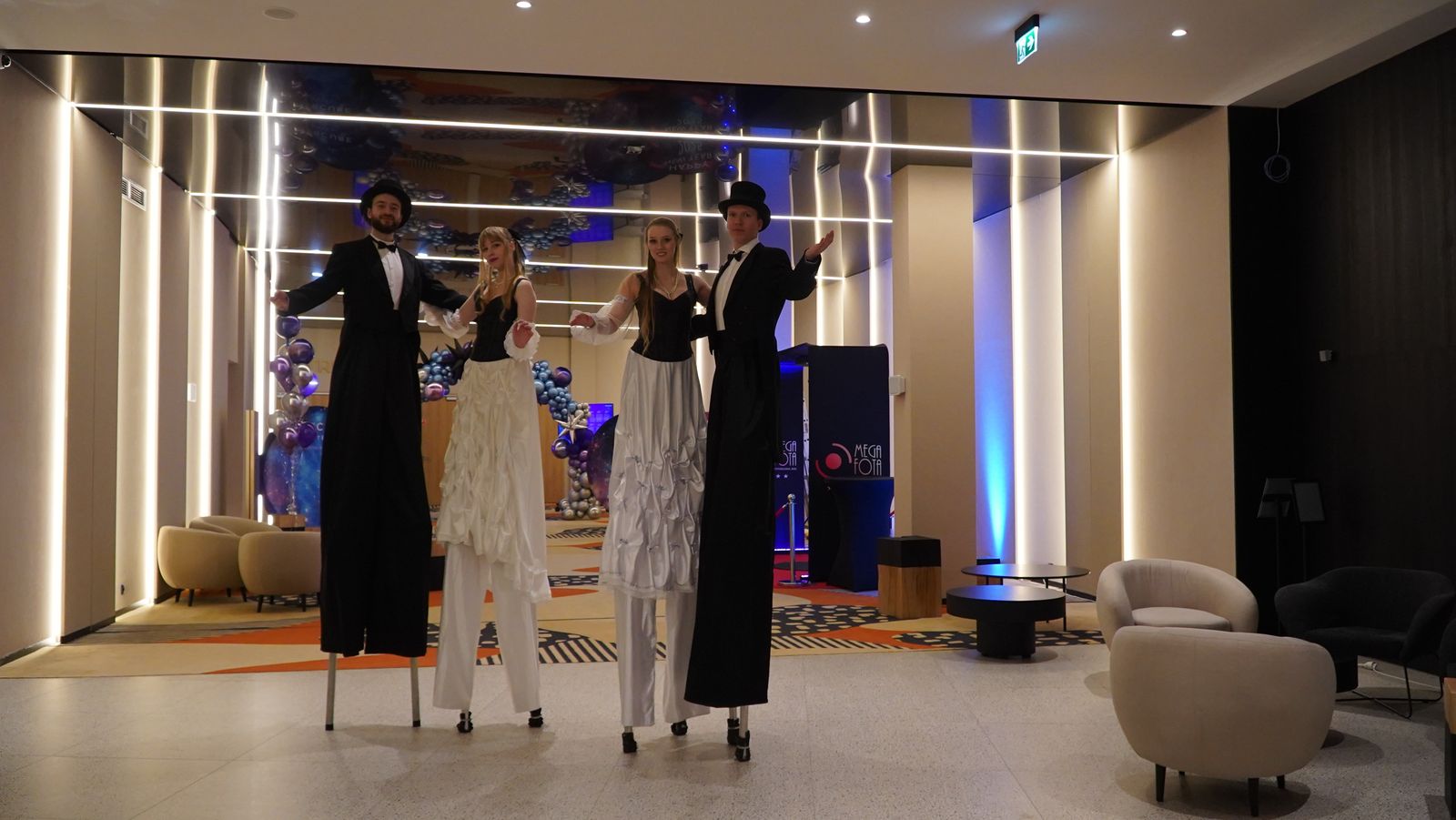 Szczudlarze witający gości w hotelowym lobby