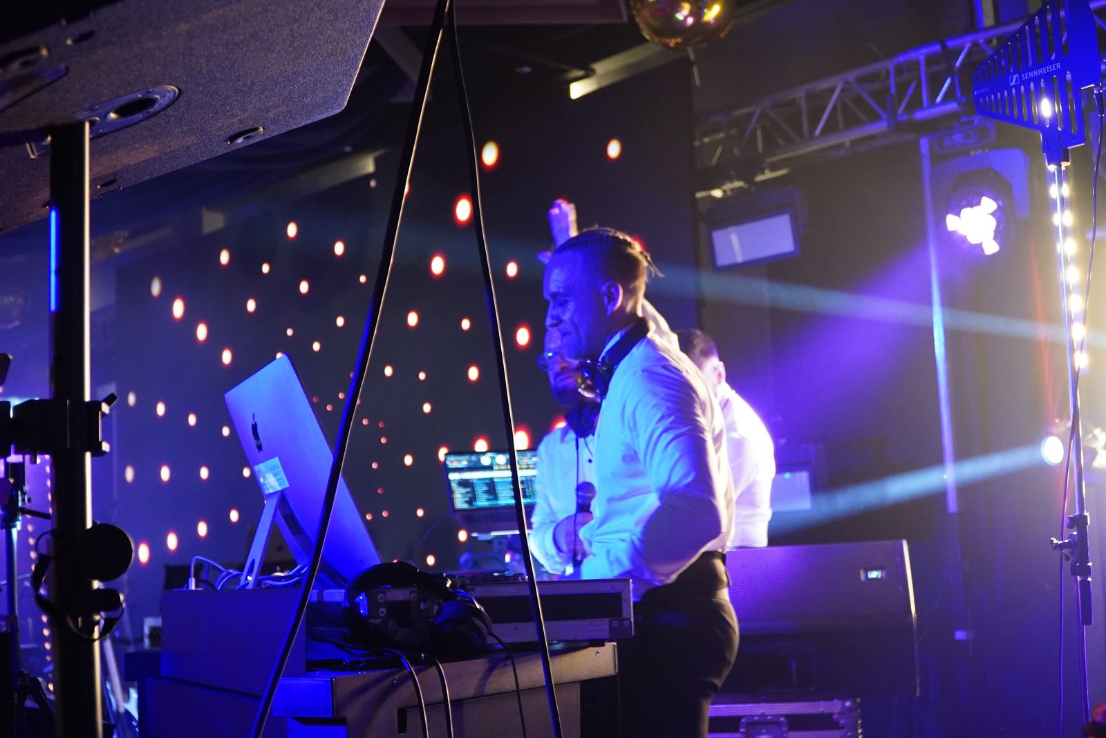 DJ przy konsolecie na tle świetlnej scenografii